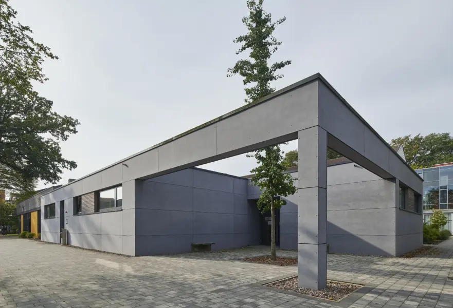 Moderner, kubischer Bau mit grauer Fassade und Baum vor dem Eingangsbereich, Gebäude: Mensa und Fachräume der Marienschule