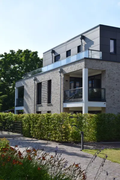 Modernes Wohngebäude mit Glasbalkon, Backsteinfassade und Garten in Oldenburg