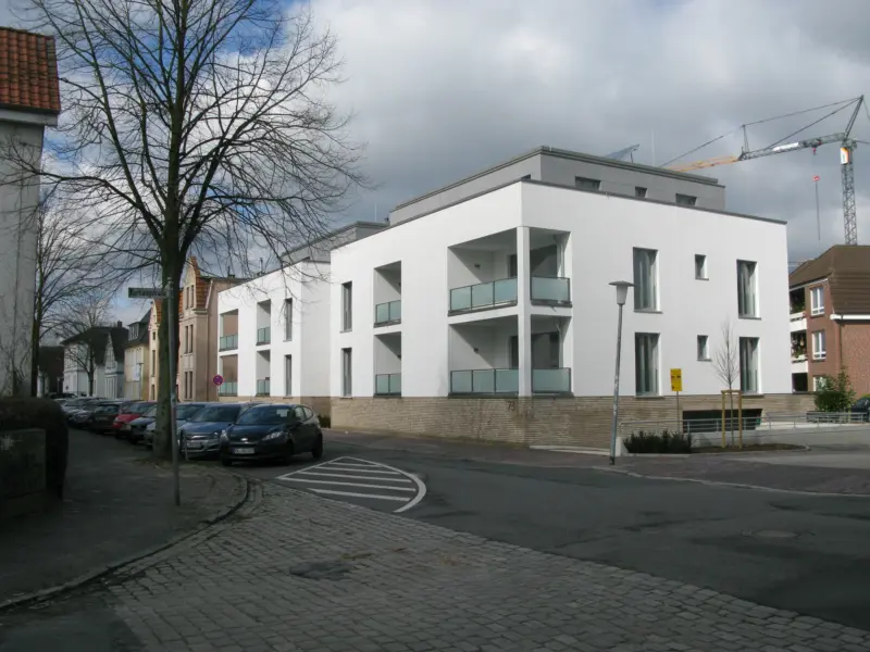 Moderne, weiße Wohnarchitektur mit großen Fenstern in der Lindenstraße an einer ruhigen, gepflasterten Straße